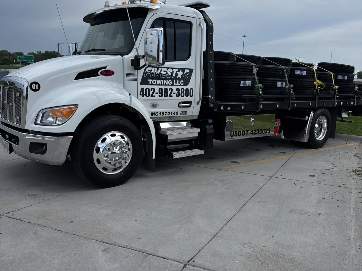 Flatbed tow truck with an empty deck ready to load